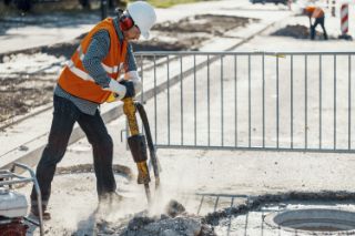A worker on a construction site using a jackhammer