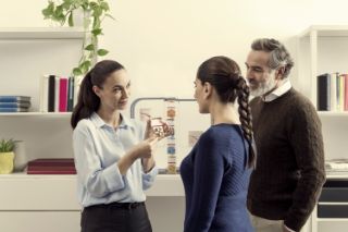 A couple talking with an Amplifon hearing professional at an Amplifon center