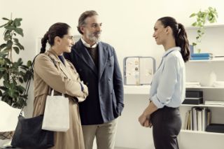 An elderly couple talking with an Amplifon hearing professional