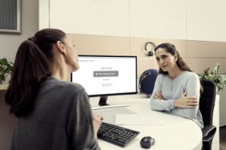 Woman taking hearing evaluation and listenig to her doctor