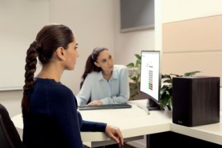 A senior woman looking at her hearing screening results on a computer