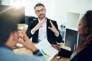 A businessman having a conversation with two people