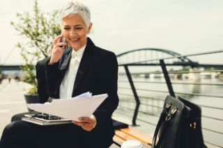 A woman on the phone checks some documents