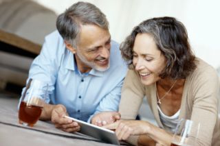 Couple smiling looking at their smartphones 
