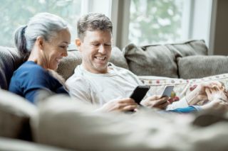Couple on a sofa using their smartphones