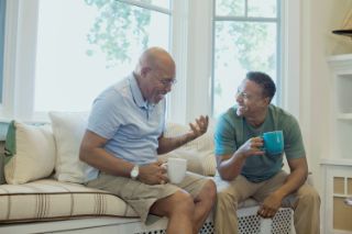 Two friends sitting on a couch having fun