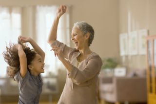 A grandmother having fun with her granddaughter at home