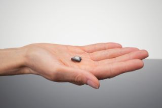 An ITE hearing aid in someone's hand