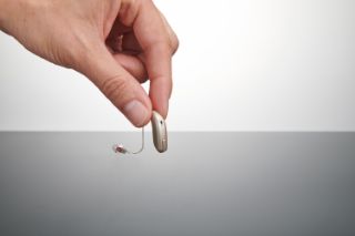 Hand holding hearing aid