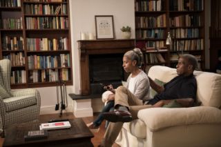 Couple sitting on their sofa holding a remote control