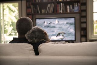 A couple watching TV on a sofa