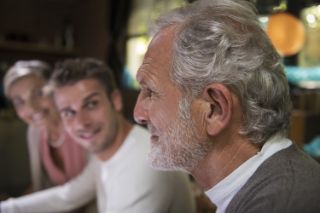 An elderly man seen in profile during a family birthday party