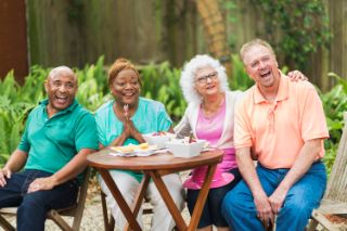 Senior friends gathered around a table laughing