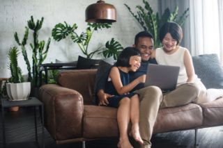 Family on a couch using a laptop