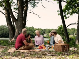 A family sitting together in nature for a picnic