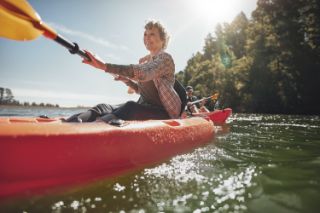 A senior woman kayaking on a lake