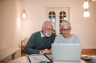 A senior couple searching for information on their computer