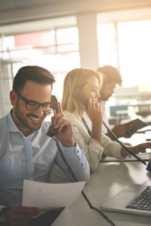 Colleagues on the phone at work smiling 