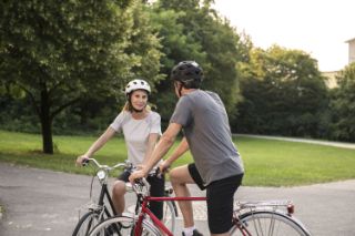 A couple biking together in a park