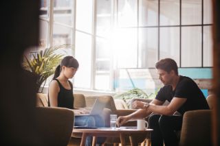 A woman and a man working together in a coworking space