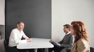 Two people having a meeting with an Amplifon hearing professional