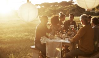 Una familia reunida alrededor de una mesa para un picnic al aire libre