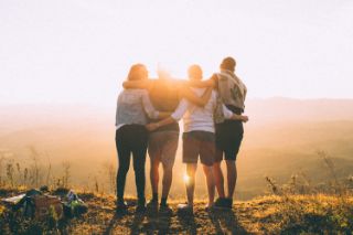 Grupo de amigos frente al sol disfrutando de una vista