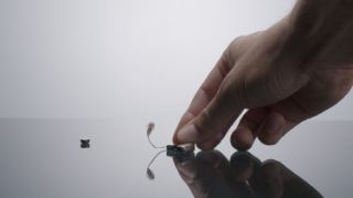 Someone changing the battery of a hearing aid