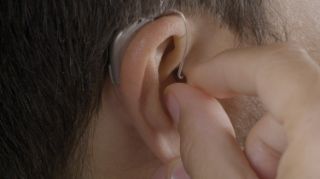 Man inserting hearing aids