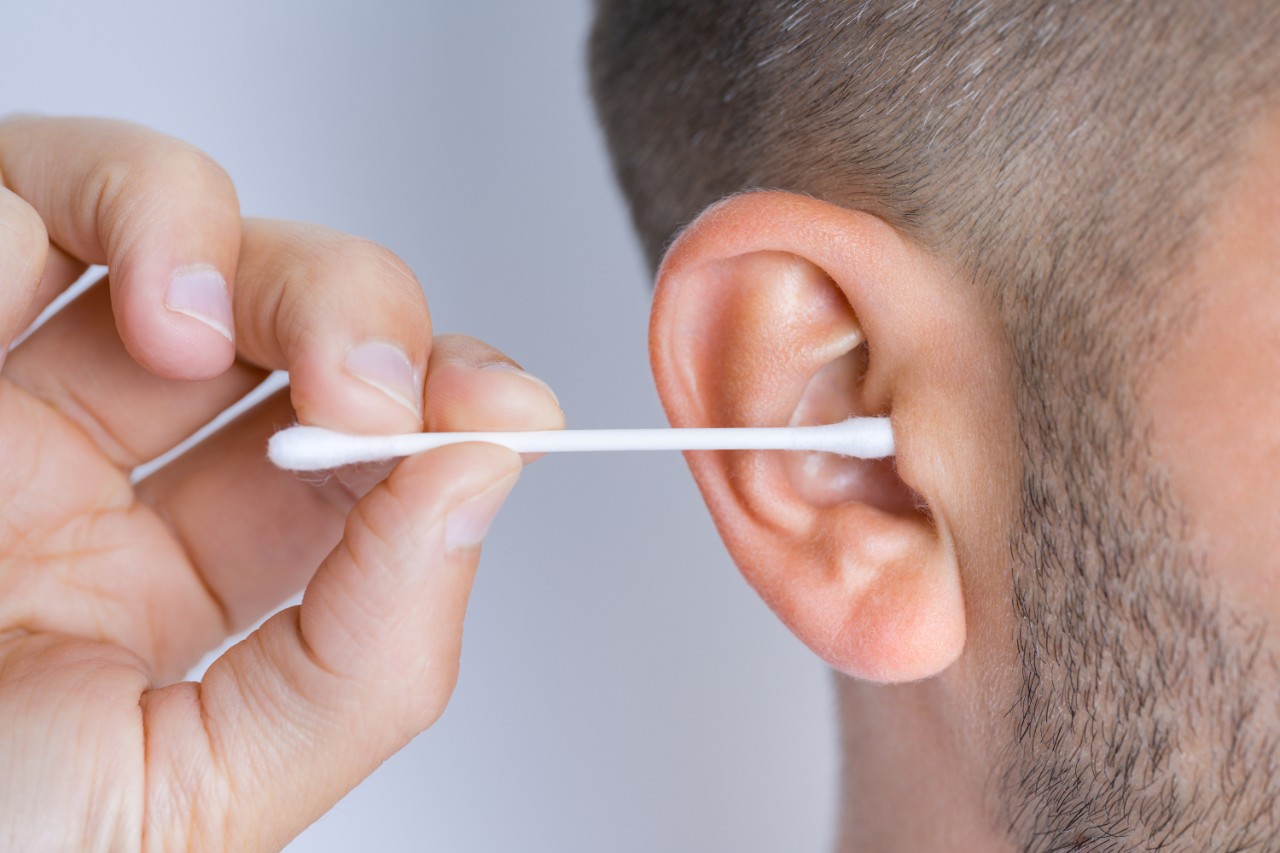 Man cleaning ear with Q-tip