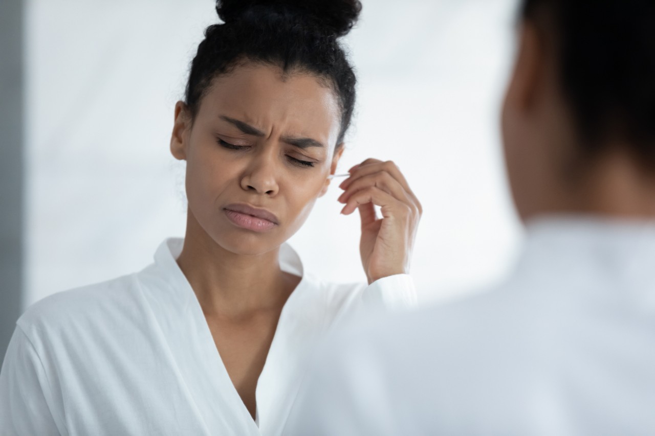 Woman cleaning ears with Qtip