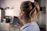 Woman with hearing aid drinking coffee