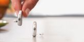 Hand picking up hearing aids