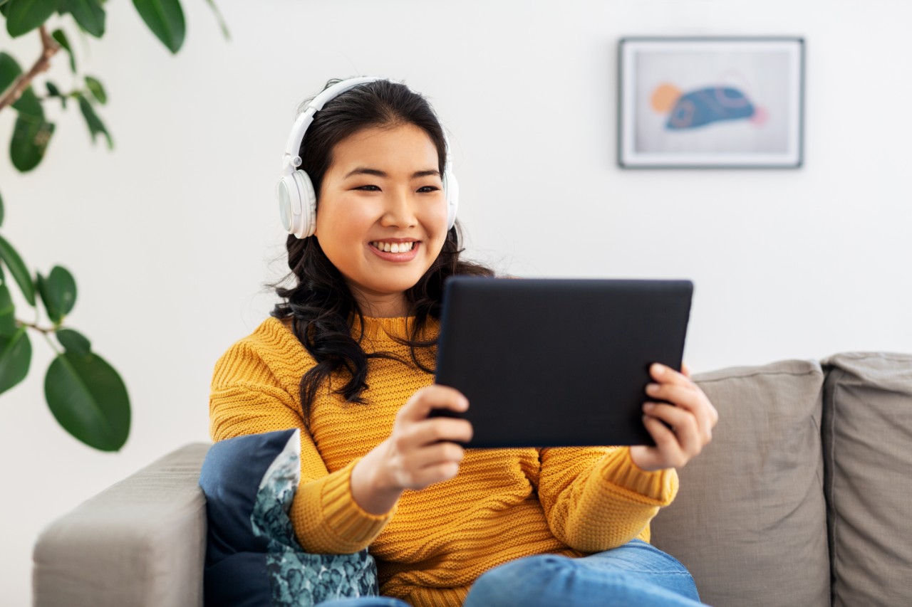 Woman on tablet wearing headphones