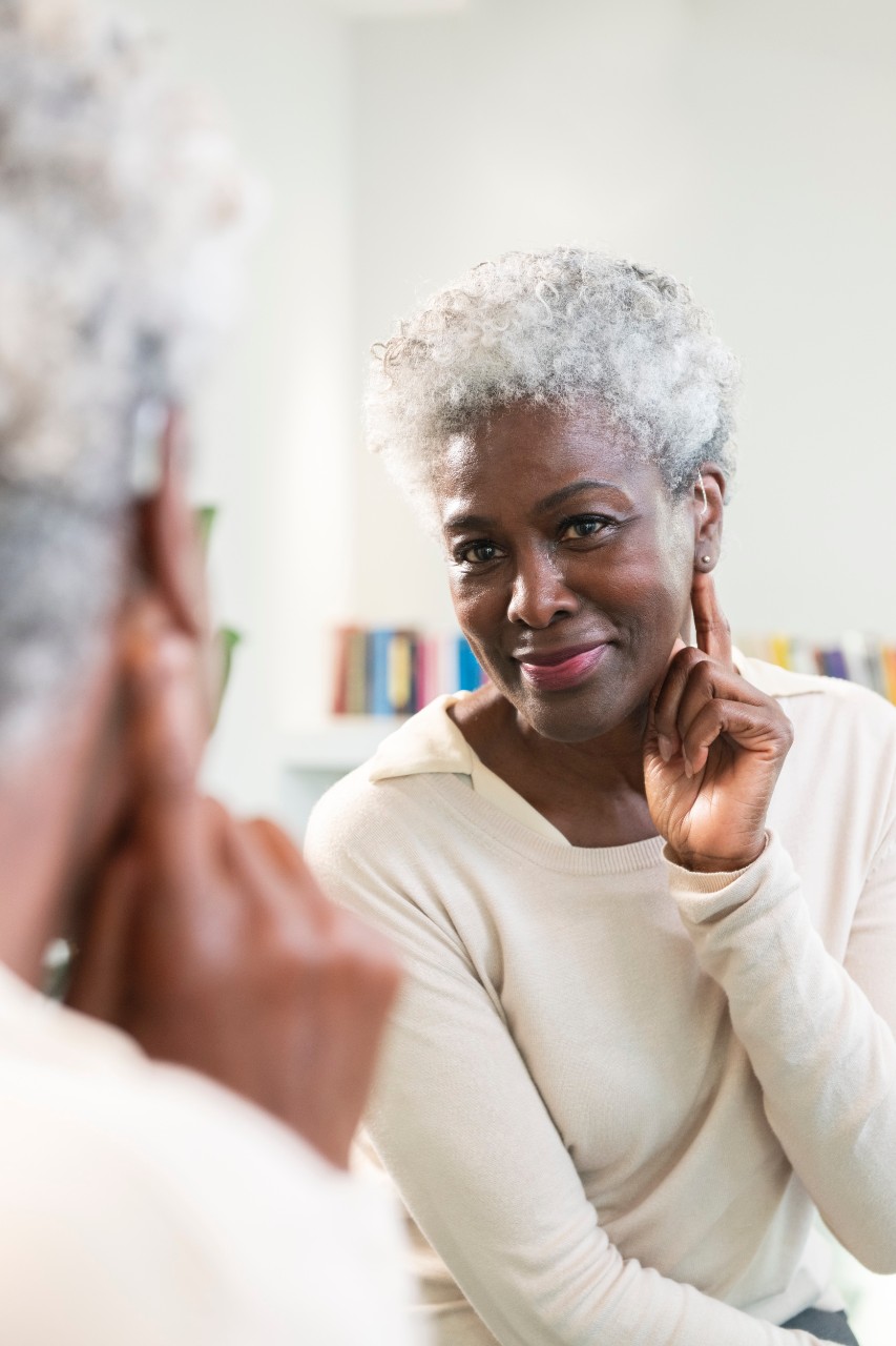 Woman smiling while wearing a hearing aid
