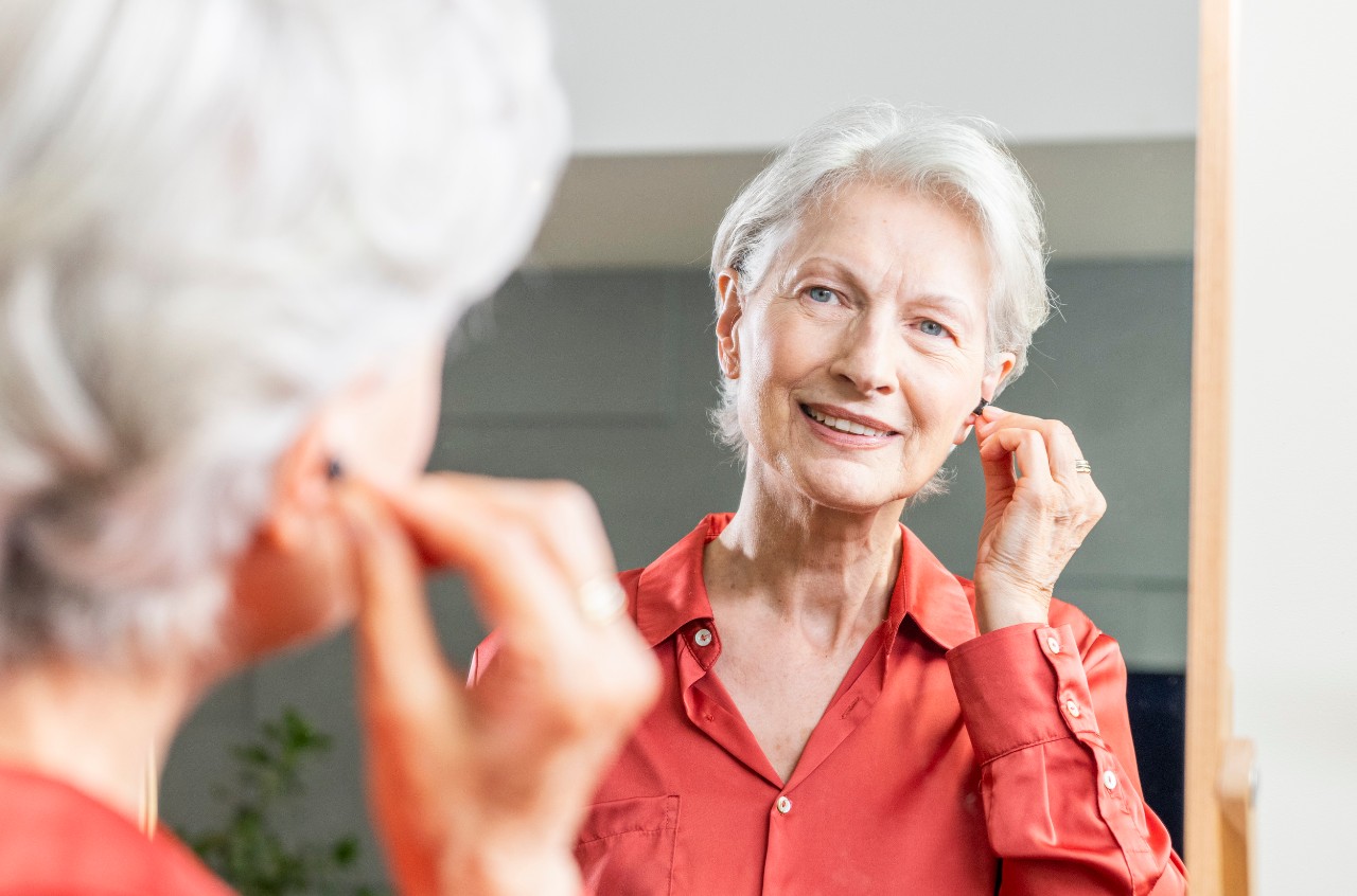 Woman inserting hearing aid