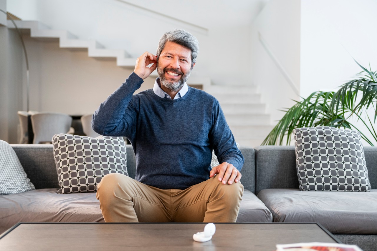 Man wearing a mini hearing aids with his case