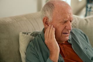 Senior man smilign with ear pain