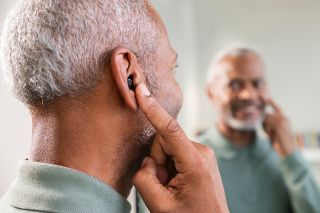 Man inserting hearing aid