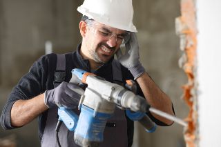 A worker touching his ear