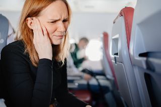 Woman touching her muffled ears
