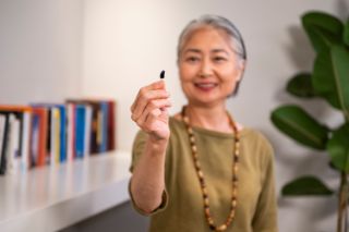 Woman holding a hearing aid in her hand