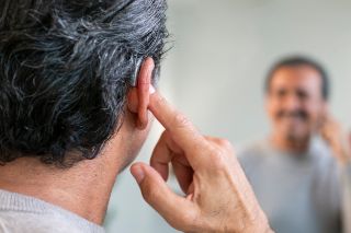 A man touching his ear
