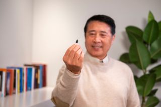 Man holding his hearing aid in his hand