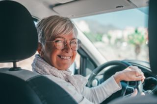 A woman smiles while driving