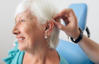 A elderly woman with a hearing aid